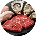 Steak, oysters, and chicken on slate